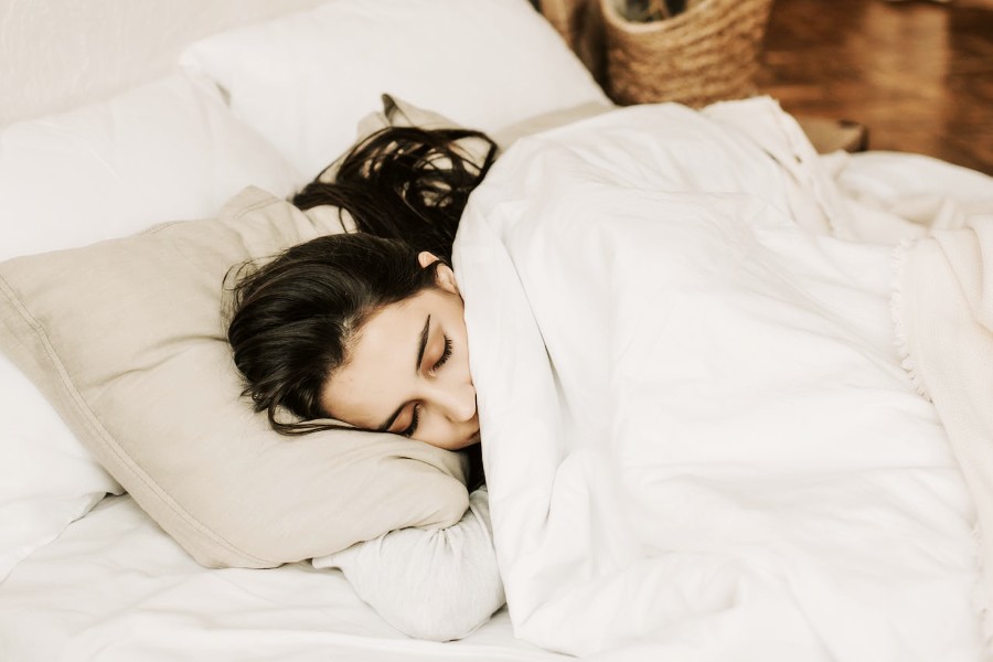 A woman asleep with a white comforter - low calorie canada health plan 